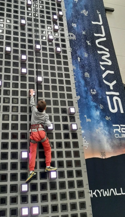Dziecko wspinające się na ściance SkyWall ustawionej na dużą wysokość