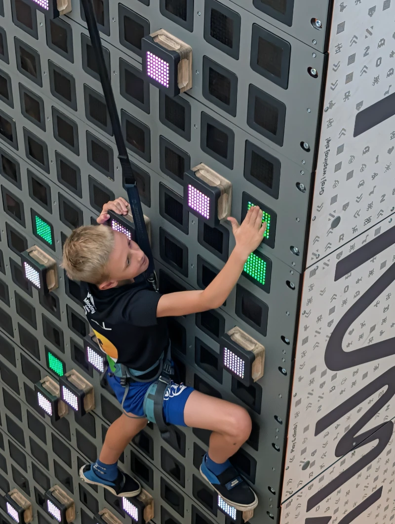 Uczeń wspinający się na interaktywnej ściance wspinaczkowej SkyWall